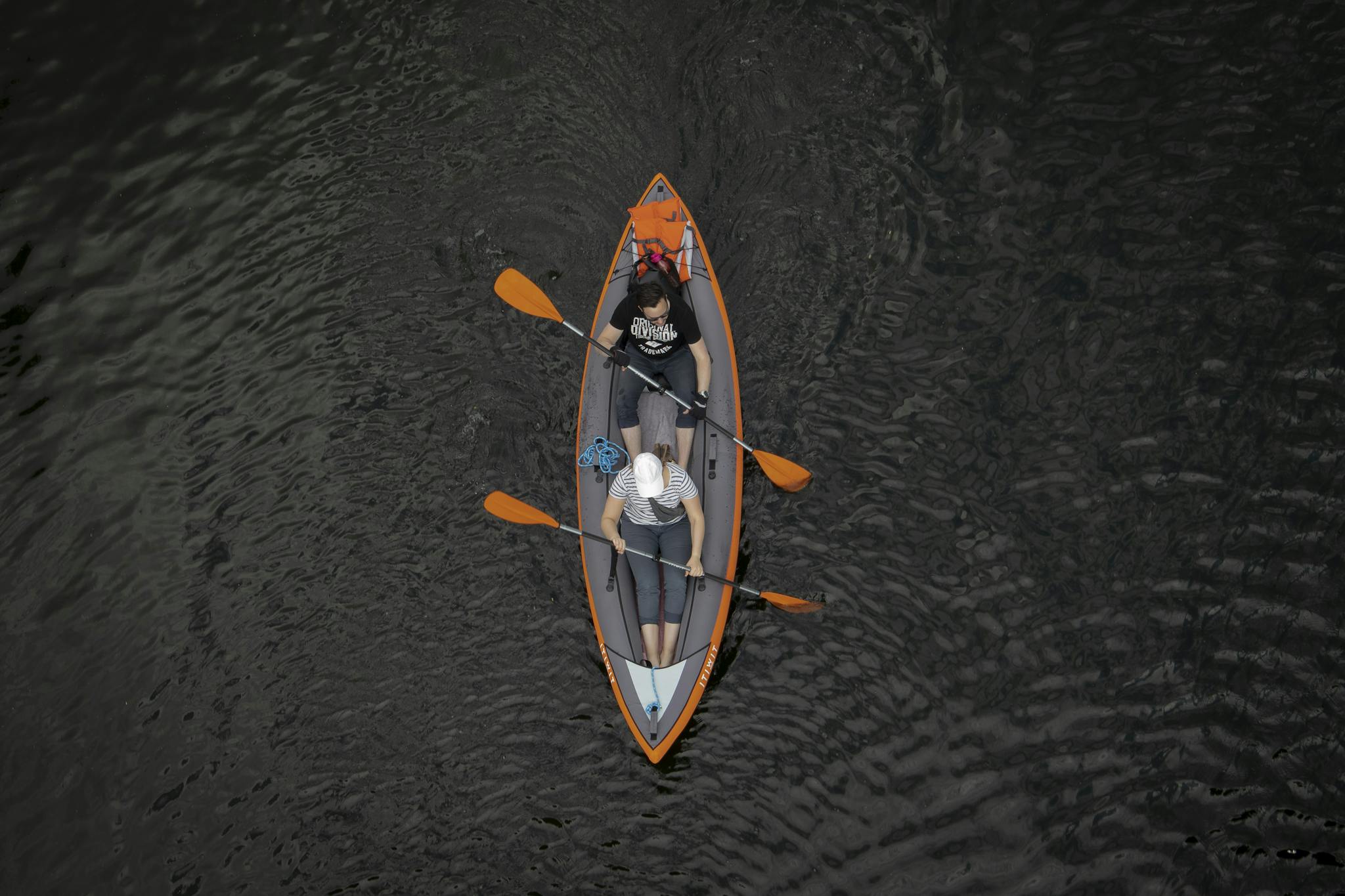 Drone shot of a couple kayaking peacefully on a calm lake, perfect for adventure seekers.