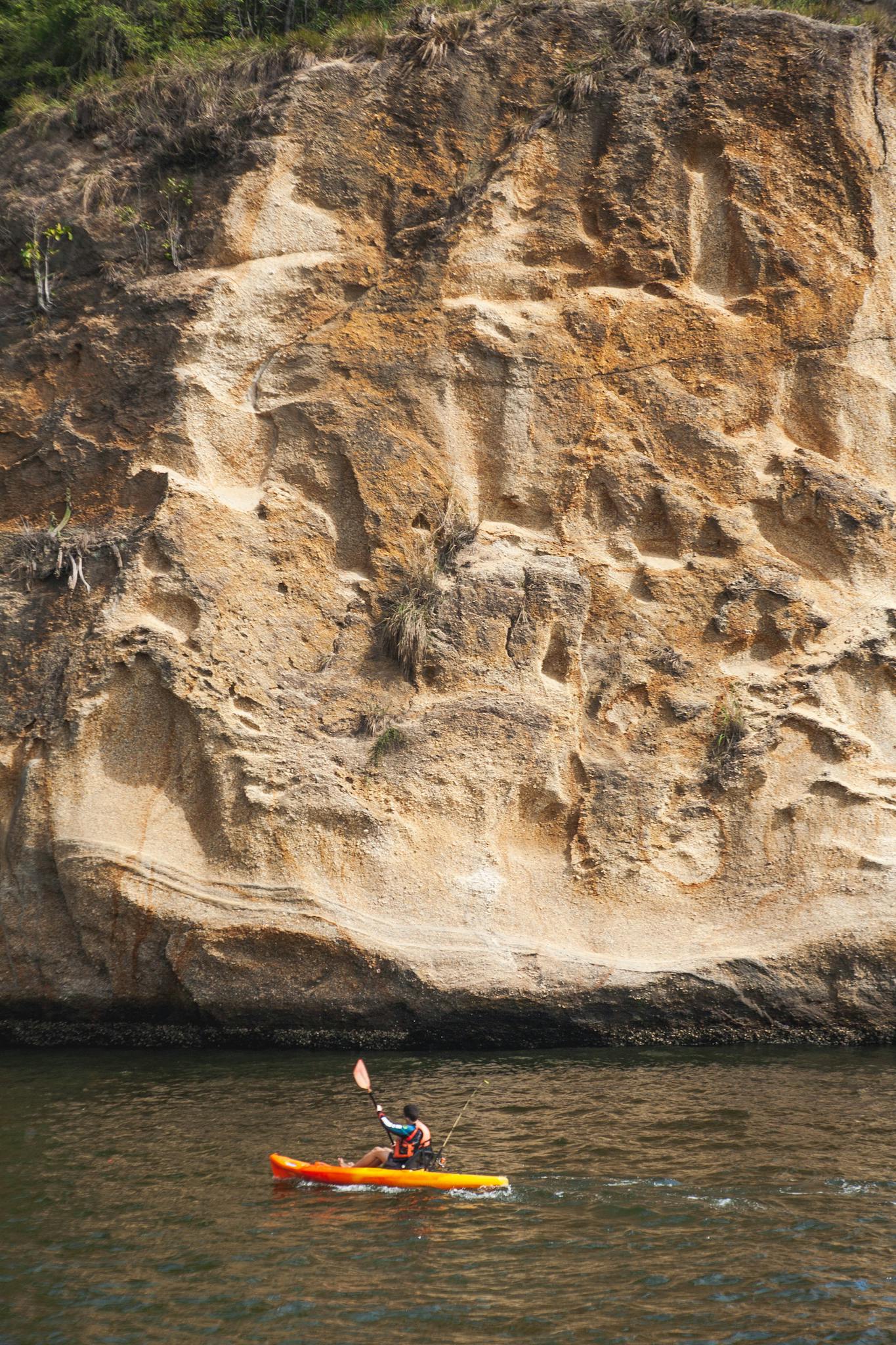 Kayaking adventure with scenic cliff backdrop, perfect for travel and outdoor enthusiasts.